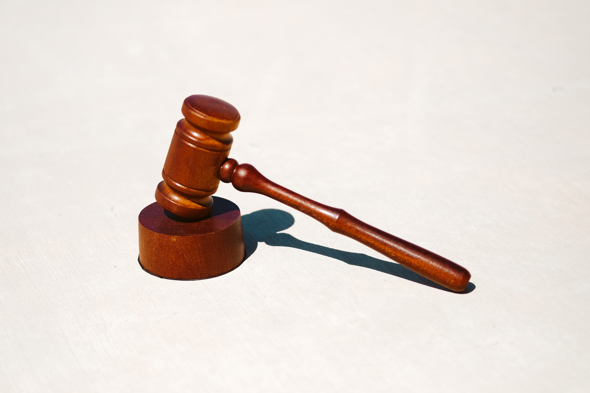 Image of a judge's gavel on a stand on a white background